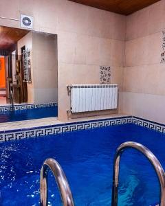 a large swimming pool with blue water in a building at White House SPA Hotel in Baku