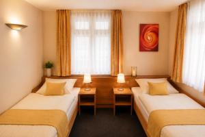 a hotel room with two beds and a window at Hotel Altes Rathaus in Ostfildern