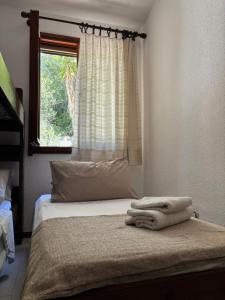 a bed with a towel on it in a bedroom at Splendida villetta Kal'e Moru in Marongiu