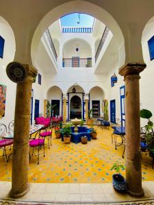 a large room with tables and chairs in a building at Riad Safi - maison historique in Safi