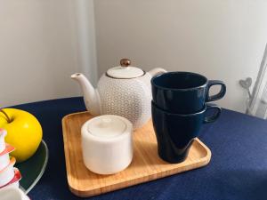 a table with a tea pot and cups on a cutting board at Apartments via Roma in Rovereto +36 photos
