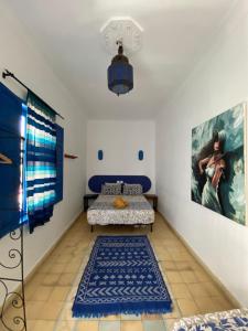 a room with a bed and a painting on the wall at Riad Safi - maison historique in Safi