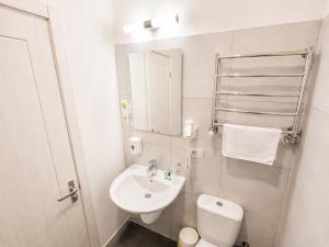a white bathroom with a toilet and a sink at Mare nero in Odesa +10 photos