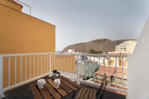 a balcony with a table and chairs on a building at Apartamento La Pista Sur in San Sebastián de la Gomera