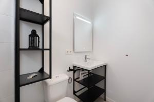a bathroom with a white toilet and a sink at Apartamento La Pista Sur in San Sebastián de la Gomera +26 photos