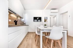 a kitchen and dining room with a white table and chairs at Sand Beach House - Host Solution in Cavallino-Treporti