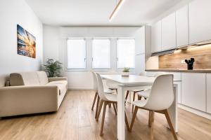 a kitchen and living room with a white table and chairs at Sand Beach House - Host Solution in Cavallino-Treporti