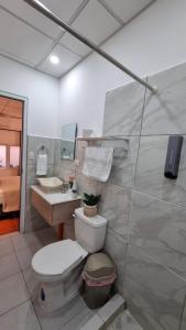 a bathroom with a toilet and a sink at AMINA Inn in Flores