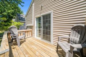 two chairs and a table on a wooden deck at Chris Cottage 1 in Chincoteague