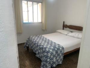 a bed in a room with a window and a bedskirtspectspectspectspects at Casa na praia bem localizada in Marataizes +12 photos