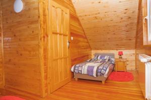 a bedroom with a bed in a wooden cabin at Domki całoroczne u Greściaków in AdamÃ³w