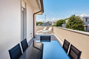 a balcony with a table and chairs on a building at Sand Beach House - Host Solution in Cavallino-Treporti
