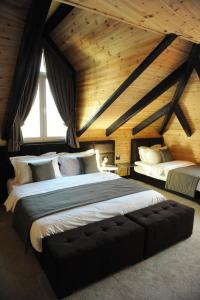 a bedroom with two beds in a room with wooden ceilings at Eurobushi Hotel in Kolgecaj
