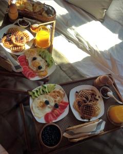 a table with plates of breakfast food on it at Eurobushi Hotel in Kolgecaj