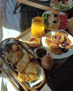 a tray of breakfast foods and a glass of orange juice at Eurobushi Hotel in Kolgecaj