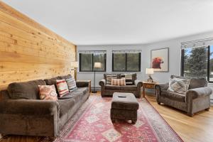a living room with couches and chairs and windows at Plaza #1404 in Keystone