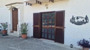 a entrance to a building with wooden doors and plants at Country Chic Antico Casale - piscina idromassaggio lettini, solarium, cinema experience, wifi, parcheggio in Caiazzo