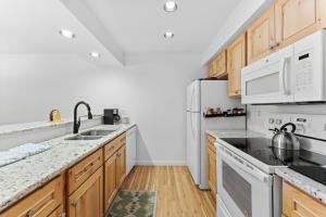 a kitchen with white appliances and wooden cabinets at Plaza #1404 in Keystone