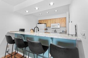 a kitchen with a blue island with black chairs at Plaza #1404 in Keystone +21 photos