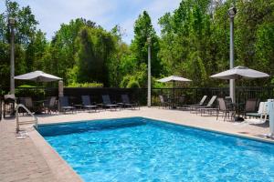 a pool with chairs and tables and umbrellas at Fairfield Inn and Suites by Marriott Saint Augustine I-95 in St. Augustine