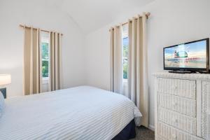 a bedroom with a bed and a tv on a dresser at Chris Cottage 3 in Chincoteague