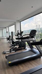 a gym with several tread machines in a room with windows at Azure Suite Apartment - AOSIS in Bagam