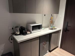 a kitchen counter with a microwave and a sink at Azure Suite Apartment - AOSIS in Bagam