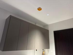 a kitchen with gray cabinets and a ceiling at Azure Suite Apartment - AOSIS in Bagam +3 photos