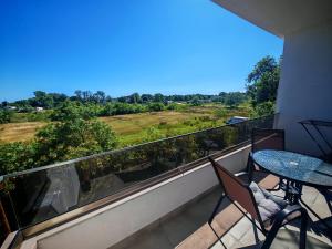 a balcony with a table and chairs and a view of a field at White apartments in Ulcinj