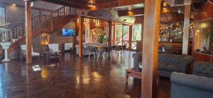 a living room with a staircase and tables and chairs at Hotel Domus Auditorium Suites in Villa Carlos Paz