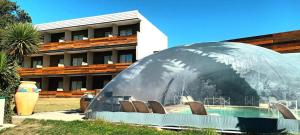 a domed building with aillion chairs in front of a building at Hotel Domus Auditorium Suites in Villa Carlos Paz