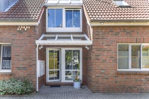 a red brick house with white windows at 50081... in Carolinensiel