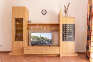a television in a wooden entertainment center with a clock at 50081... in Carolinensiel
