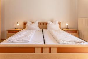 a bedroom with two beds with white sheets and pillows at 50081... in Carolinensiel