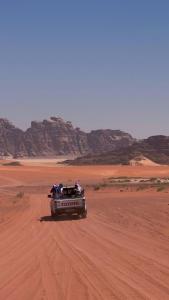 a car driving through the desert on a dirt road at وادي رم in Disah