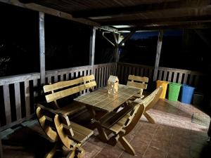 a wooden table and chairs on a porch at night at Hygge Pržno in Pržno +10 photos