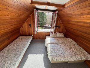 two beds in a cabin with a window at Hygge Pržno in Pržno