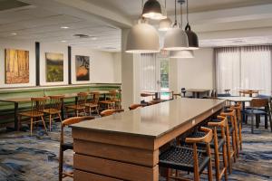 a dining room with tables and chairs and a bar at Fairfield Inn and Suites by Marriott Saint Augustine I-95 in St. Augustine