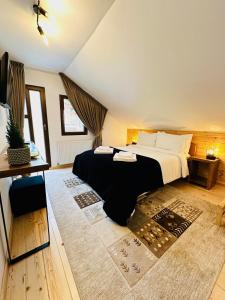 a bedroom with a large bed and a rug at Casa Rogin in Buhalniţa
