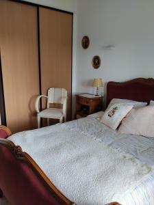 ein Schlafzimmer mit einem Bett, einem Stuhl und einem Tisch in der Unterkunft Petit Lu in Quincampoix