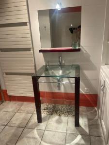 a glass sink in a bathroom with a mirror at Appartement calme et serein in Vals-près-le-Puy