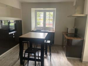 a kitchen with a table and some chairs in it at Appartement calme et serein in Vals-près-le-Puy