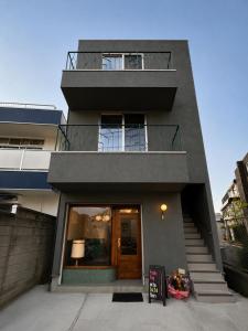 aominium building with a staircase leading to the front door at Telegraph in Kamakura