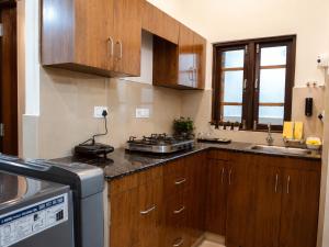a kitchen with wooden cabinets and a stove top oven at Nature View Retreat in Rishīkesh