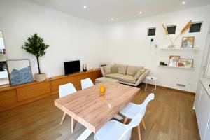 a living room with a wooden table and white chairs at Casa Federica by MOH in Grottaglie