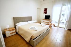 a bedroom with a large bed with towels on it at Casa Federica by MOH in Grottaglie +15 photos
