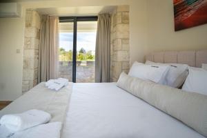 a bedroom with a large white bed and a window at The Olive Path in Kalandra +274 photos