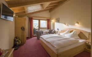 a bedroom with a large white bed in a room at Hotel-Garni Klocker in Kaltenbach