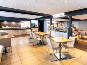 a restaurant with tables and chairs and a bar at ibis Styles Brive Ouest in Brive-la-Gaillarde