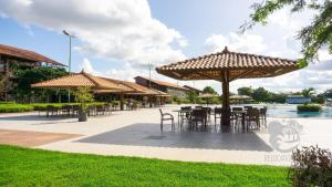 a patio with tables and chairs and umbrellas at Ground floor flat with two suites (up to 8 people) at Canarius Resort in Gravatá in Gravatá
